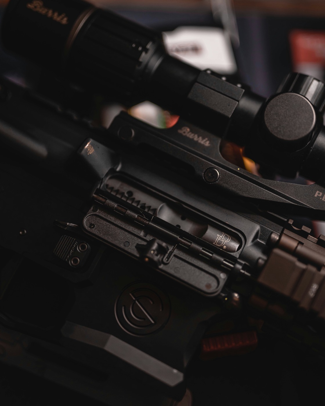 Close-up of a rifle receiver and optic on a workbench